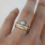 Tereza – Un delicato anello in oro con un opale scintillante e contorni trasparenti.