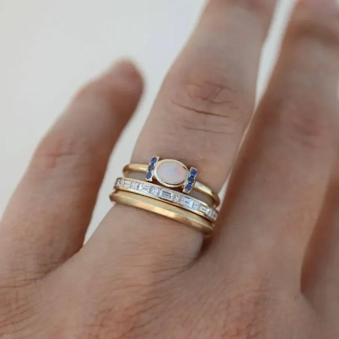 Tereza – Un delicato anello in oro con un opale scintillante e contorni trasparenti.