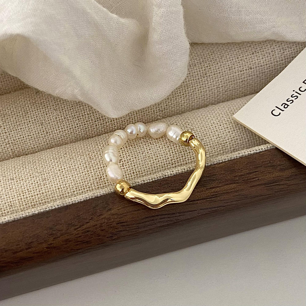 Elisa - Un anello di perle giocoso con un cuore dorato.
