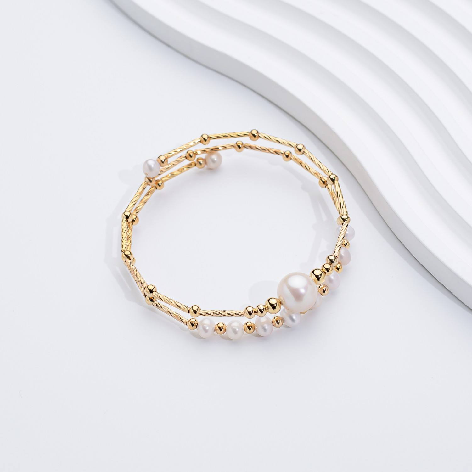Margrit – Orecchini in oro con disposizione asimmetrica di perle.