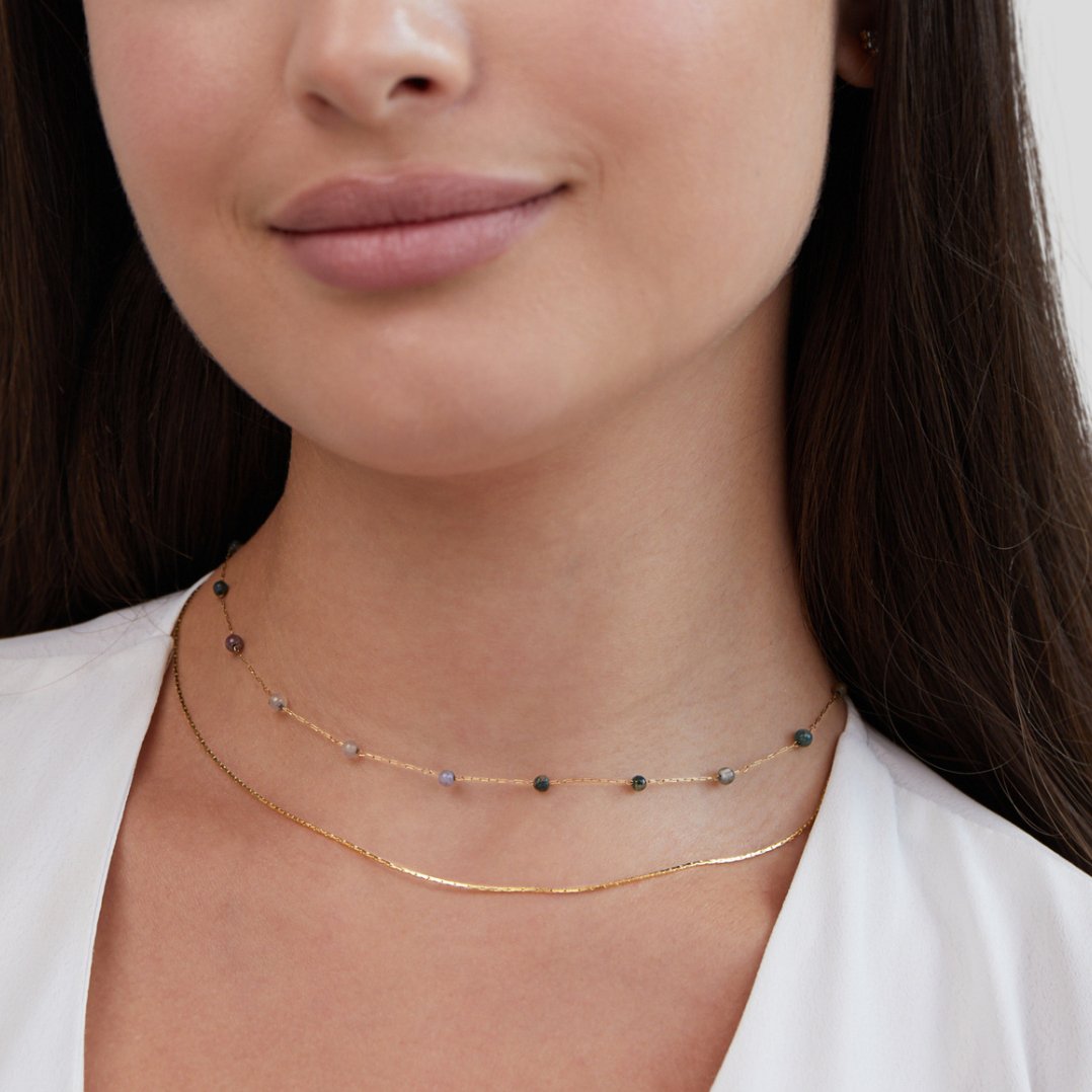 Helga – Collana a doppio strato con piccoli dettagli colorati.