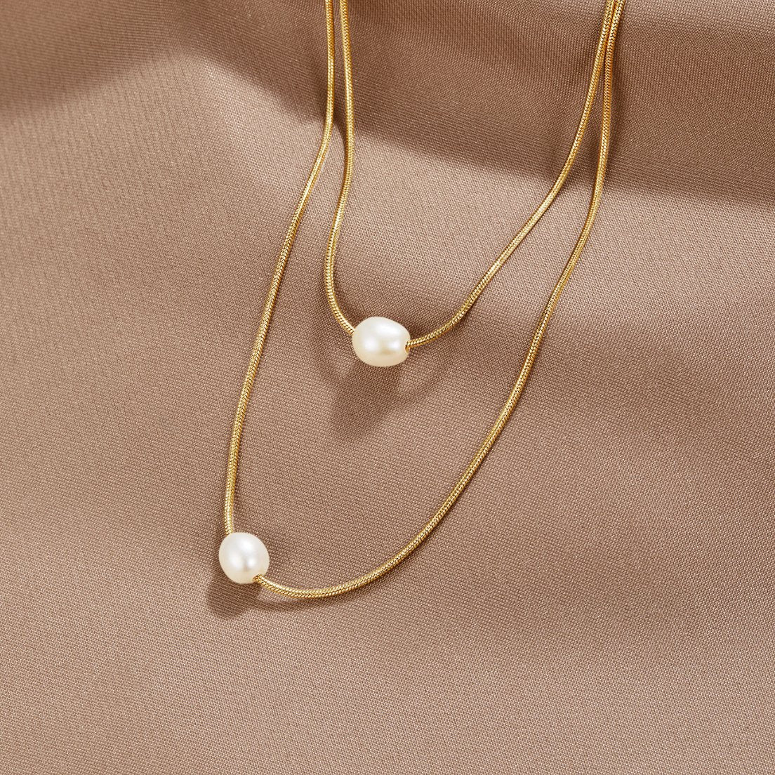 Sabina – Catena in oro a doppio strato con pietra scura.