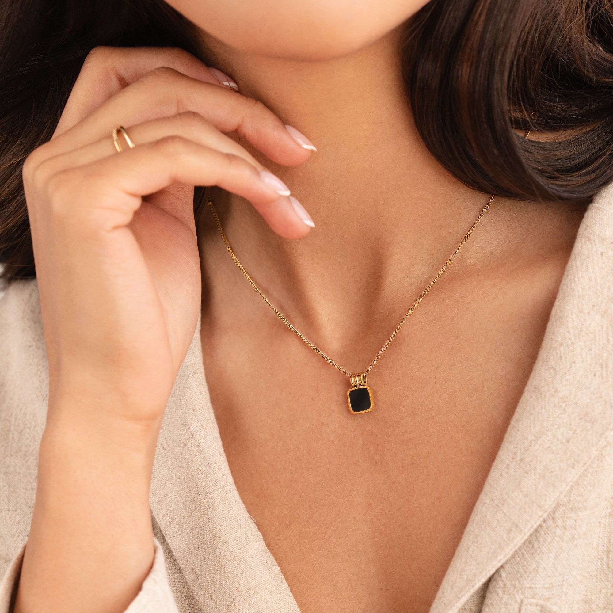 Selina - Collana in oro con pietra scura.