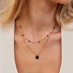 Selina - Collana in oro con pietra scura.