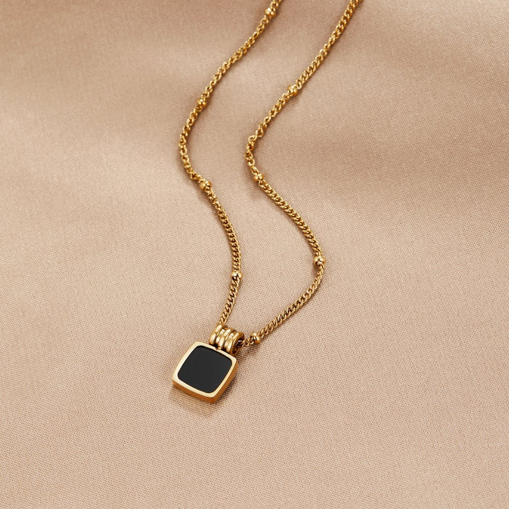 Selina - Collana in oro con pietra scura.